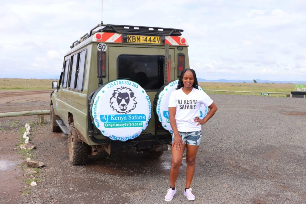 Tourist posing next to a 4x4 vehicle before a cultural masai village visit.
