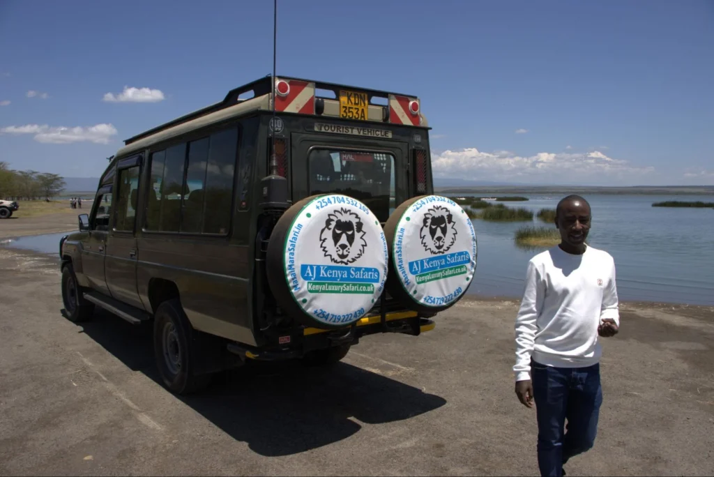 A professional guide standing near a 4x4 vehicle during a Kenya safari tour.