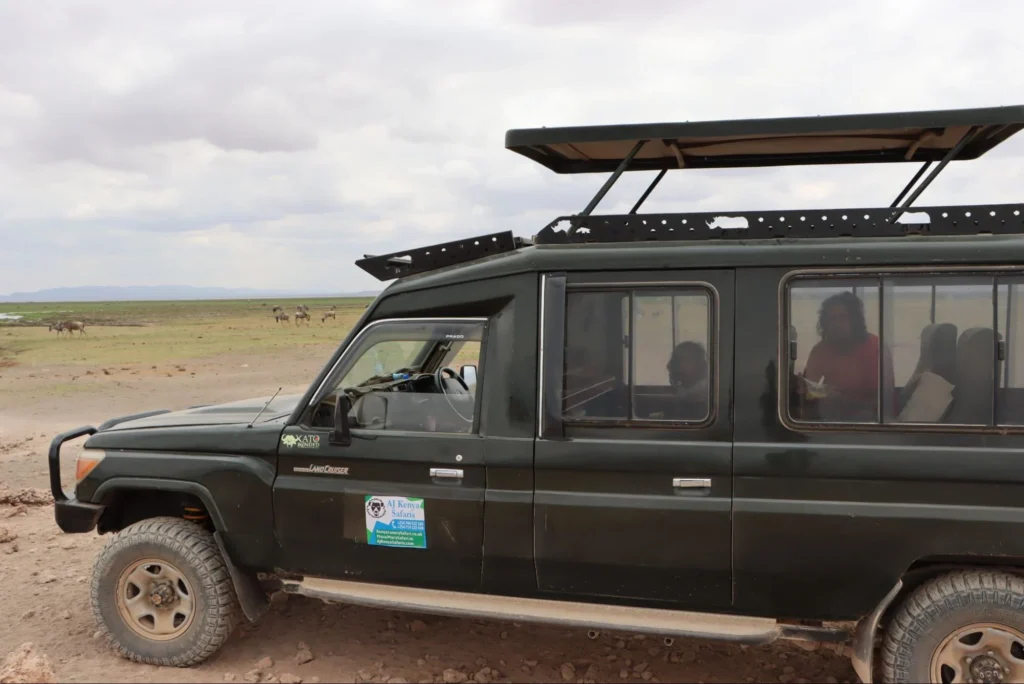 Side view of a 4x4 safari land cruiser watching wildlife across the open plains.