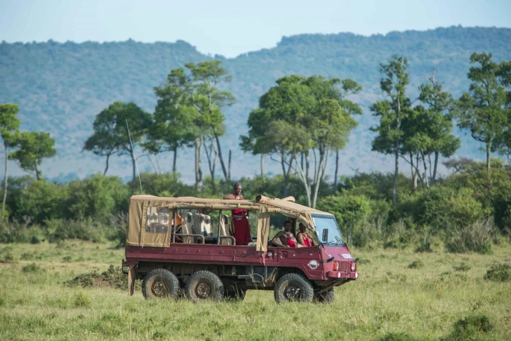 A red 6x6 safari vehicle used by Mara Engai Wilderness Lodge in the savannah.