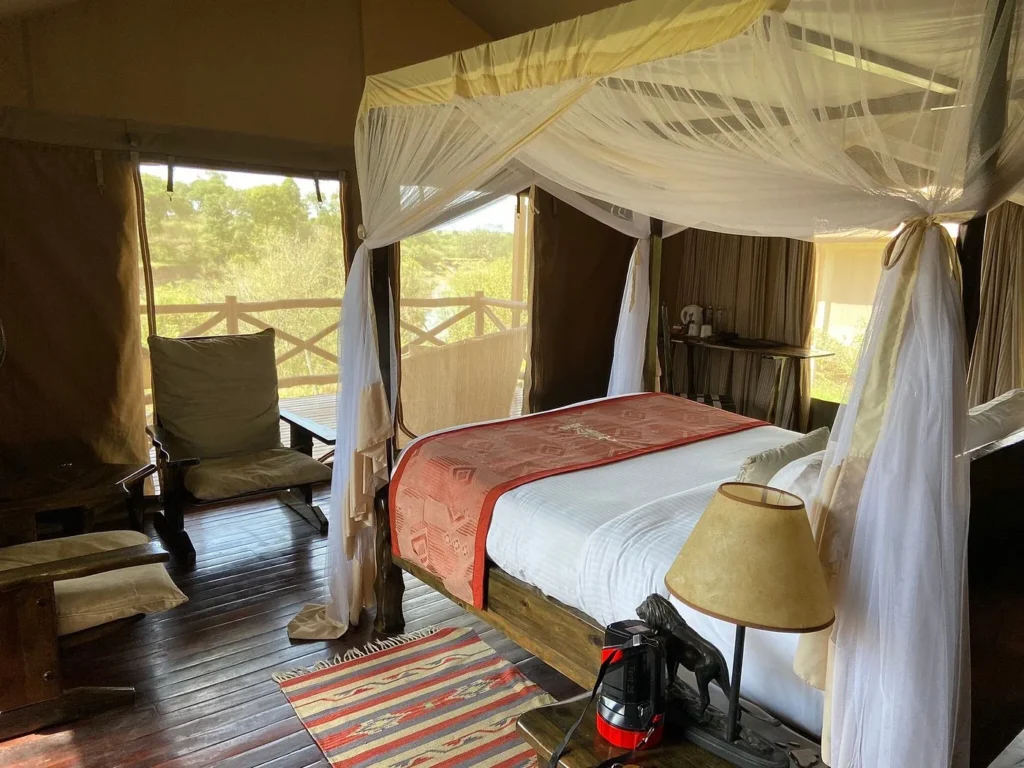 Luxury tent interior at Ashnil Mara Camp featuring a canopy bed and river views.