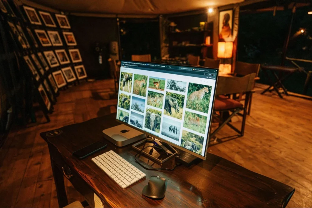 Digital editing workstation displaying safari photos inside the Mara Bush Camp photographer lounge.