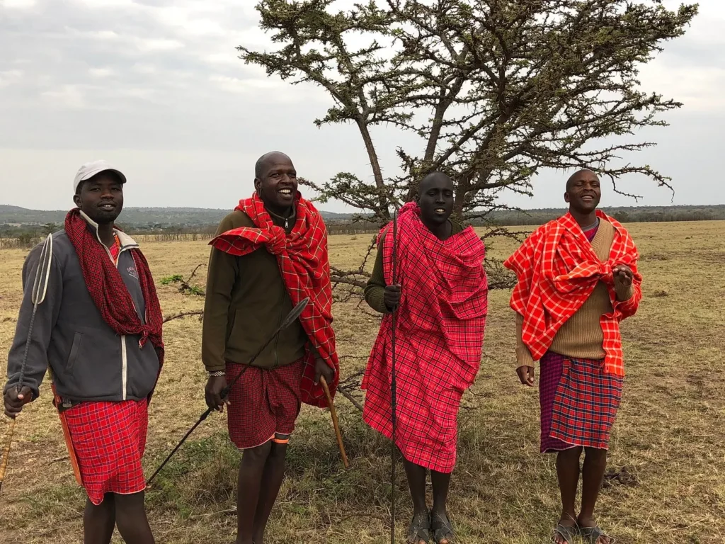 Maasai guides from Basecamp Masai Mara standing in traditional clothing on the savannah plains.